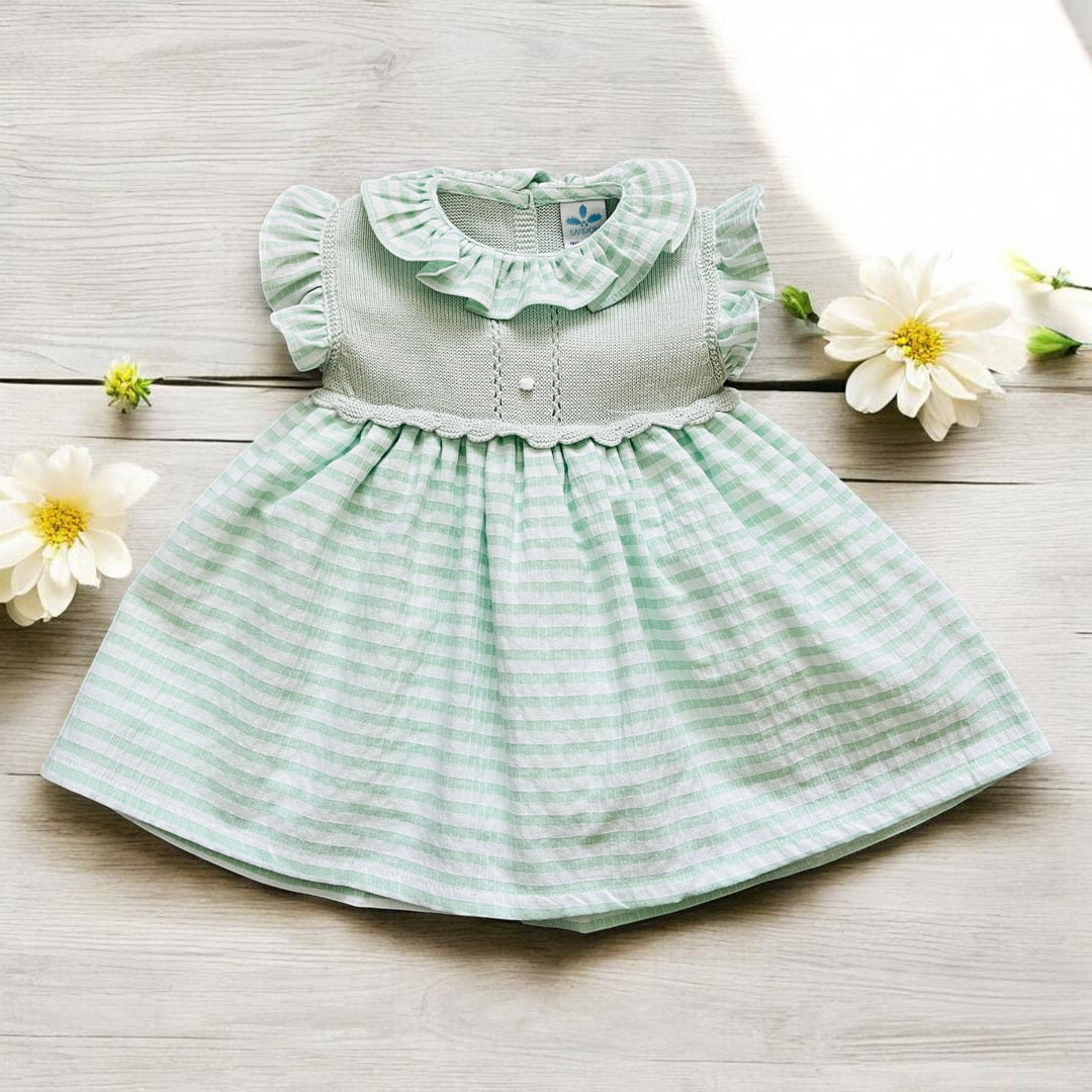 Green striped dress on a wooden surface with flowers