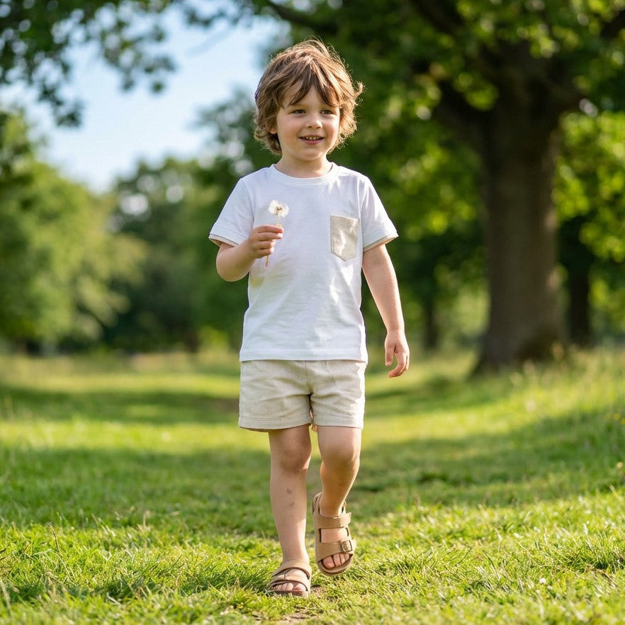 Child walking in a park holding a flower